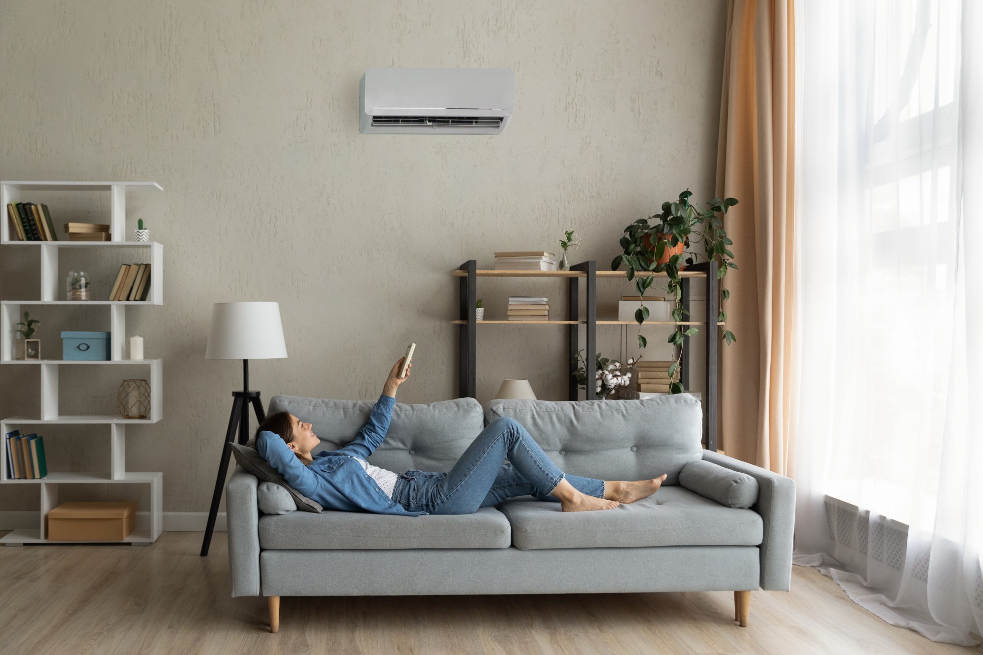 woman enjoying her ductless mini split air conditioner in her living room