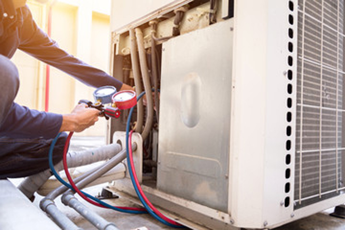 HVAC repairman performing air conditioning maintenance in El Paso