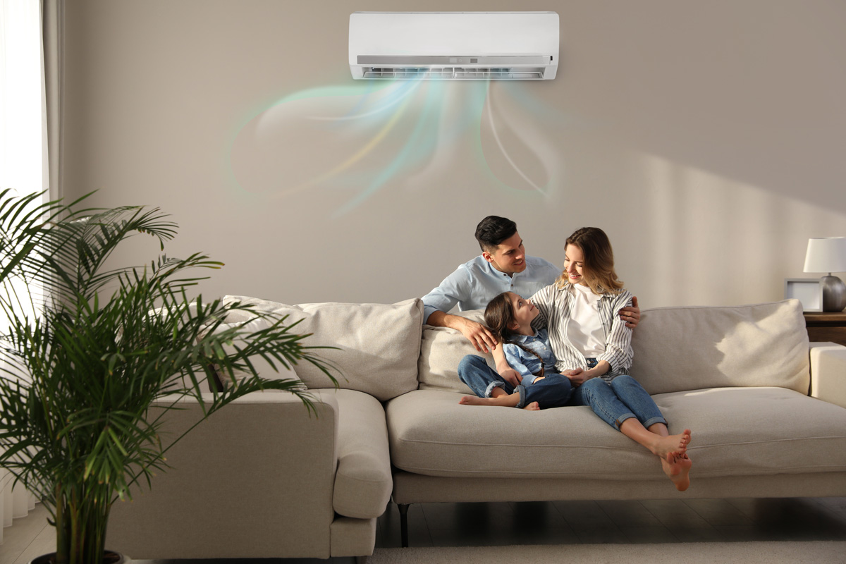 A family sitting on a couch enjoying refrigerated air from their air conditioning unit in El Paso.